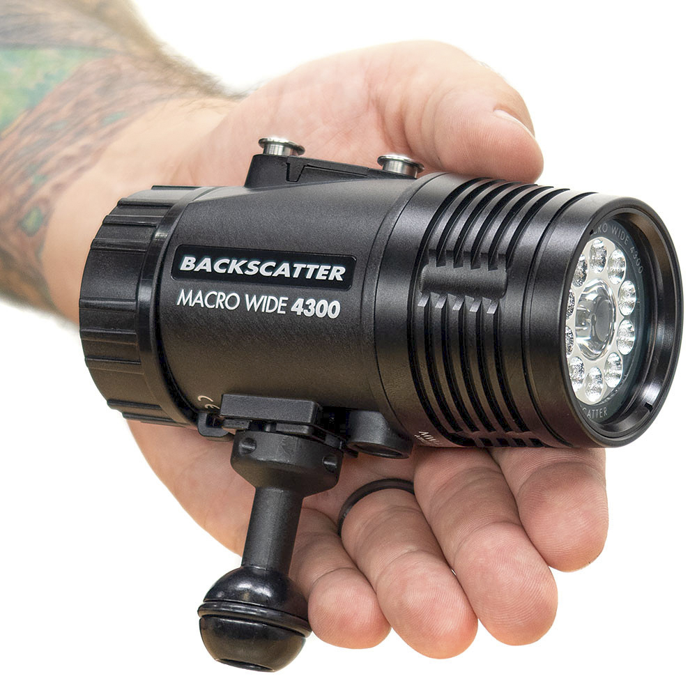 Hand holding the Backscatter Macro Wide 4300 Underwater Video Light, showing its compact size, durable black design, and LED array for wide and macro underwater photography.